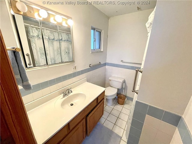 bathroom featuring tile patterned flooring, vanity, toilet, and tile walls