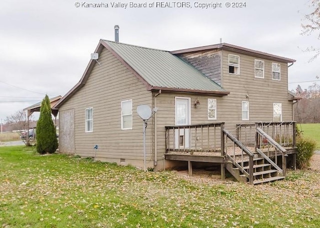 back of property with a deck and a lawn