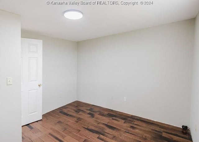 unfurnished room with dark hardwood / wood-style flooring