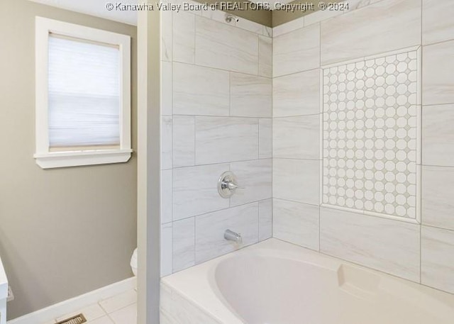 bathroom featuring tile patterned floors, toilet, and tiled shower / bath