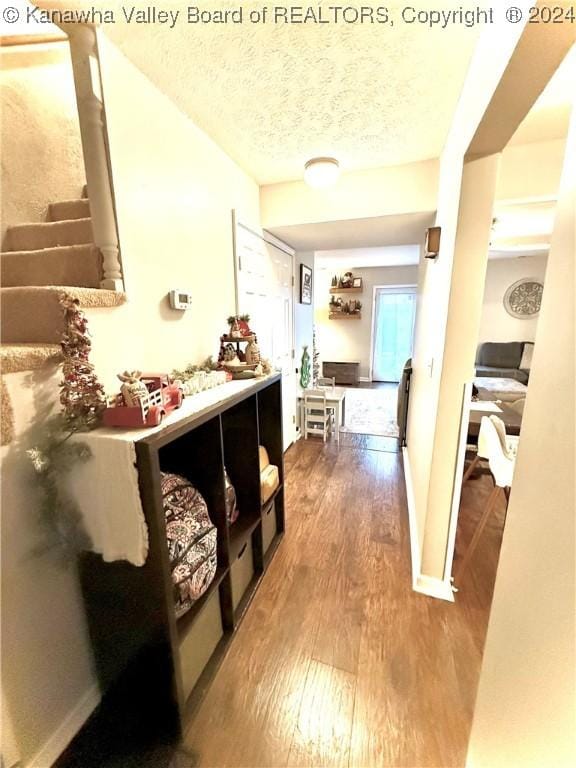 corridor featuring hardwood / wood-style floors and a textured ceiling