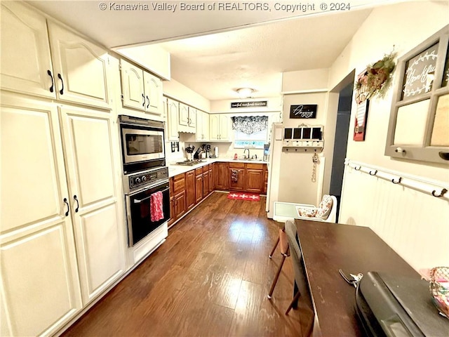 kitchen with dark wood-type flooring, stainless steel appliances, and sink