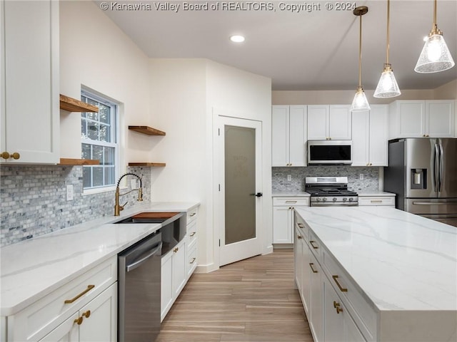 kitchen featuring light stone countertops, sink, white cabinetry, and stainless steel appliances