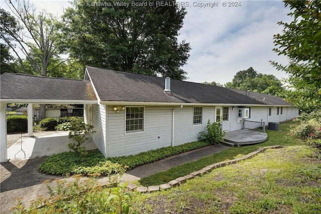 exterior space with a lawn, cooling unit, and a deck