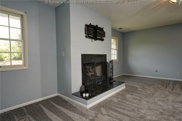 unfurnished living room with carpet floors and plenty of natural light