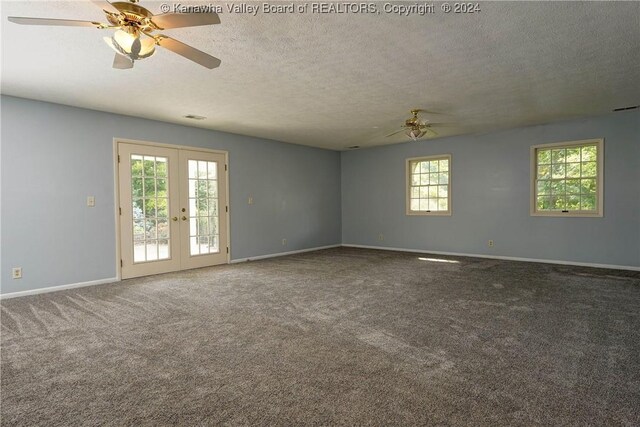 spare room with carpet flooring, a textured ceiling, a wealth of natural light, and french doors