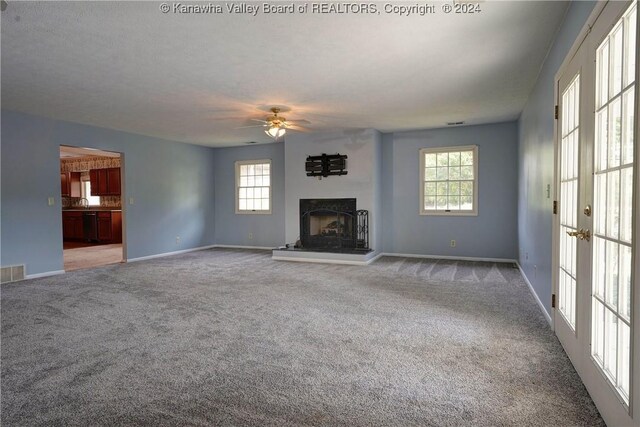 unfurnished living room with light colored carpet and ceiling fan