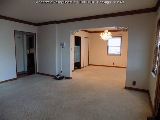 spare room with carpet, an inviting chandelier, and crown molding