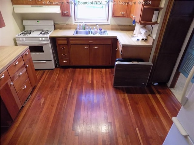 kitchen with white gas stove, sink, dark wood-type flooring, and exhaust hood