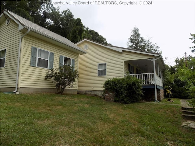 rear view of property featuring a lawn