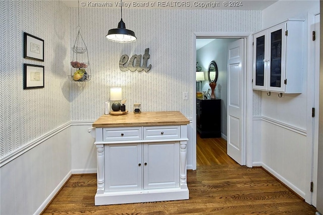 kitchen with dark hardwood / wood-style flooring, white cabinets, and decorative light fixtures