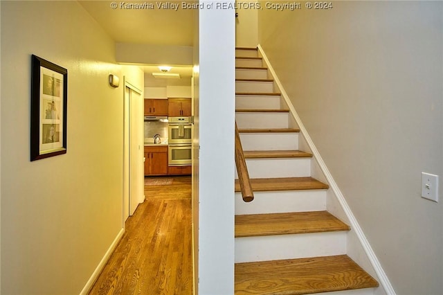 stairway featuring wood-type flooring and sink