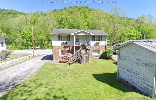 raised ranch featuring a front lawn and covered porch