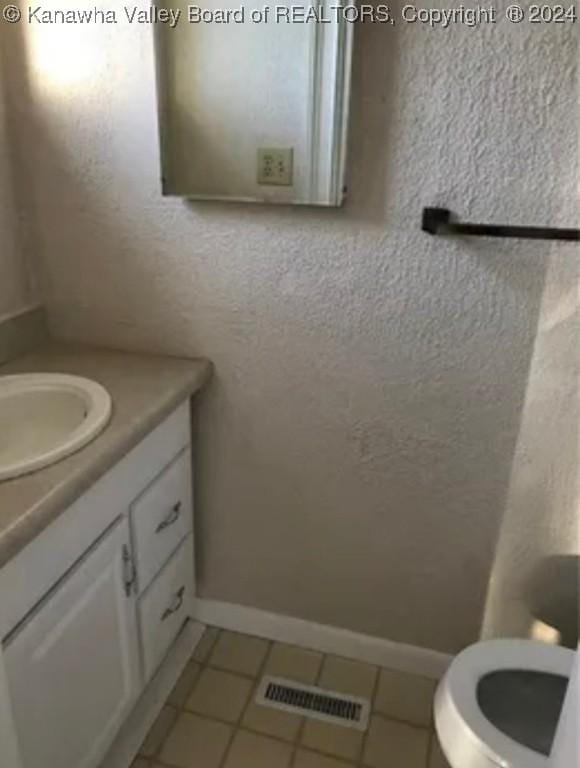 bathroom featuring toilet, vanity, and tile patterned floors