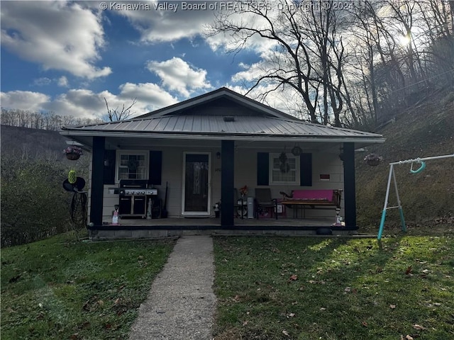 bungalow-style home with covered porch and a front yard