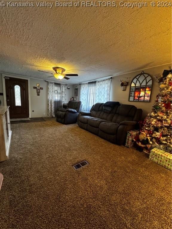 living room featuring a wealth of natural light, carpet floors, a textured ceiling, and ceiling fan