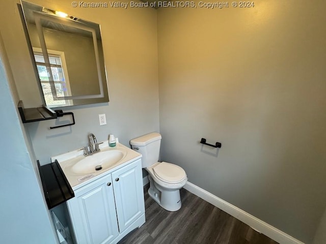 bathroom with toilet, vanity, and hardwood / wood-style flooring