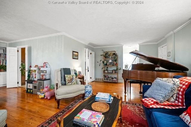 living room featuring wood-type flooring, a textured ceiling, and ornamental molding