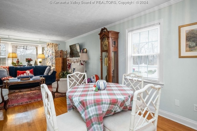 dining area with crown molding, wood-type flooring, and a textured ceiling