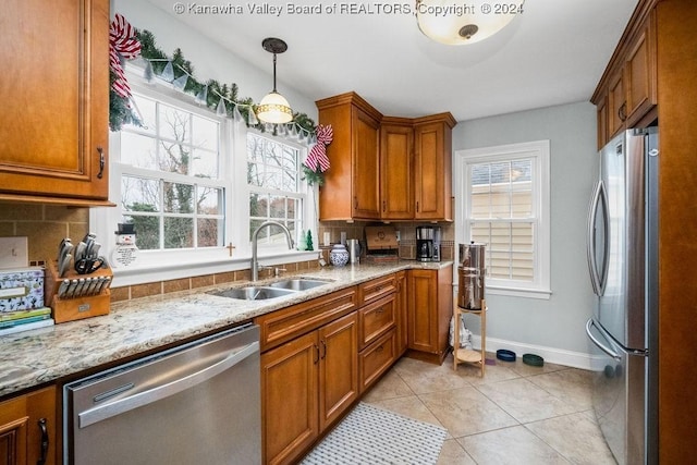 kitchen with backsplash, a healthy amount of sunlight, sink, and appliances with stainless steel finishes