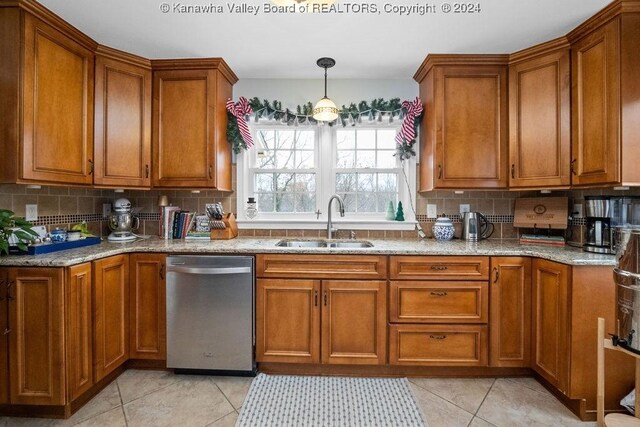 kitchen featuring tasteful backsplash, sink, light tile patterned floors, and stainless steel dishwasher