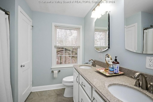 bathroom with tile patterned flooring, vanity, and toilet