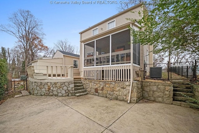 back of property with a sunroom and a patio area