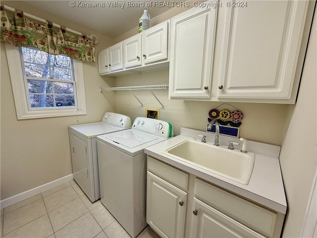 laundry area featuring cabinets, light tile patterned flooring, washing machine and dryer, and sink