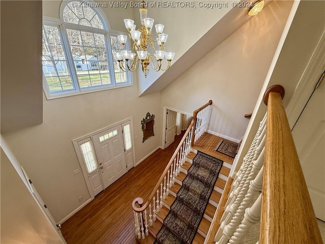 foyer featuring wood-type flooring, a high ceiling, and a chandelier