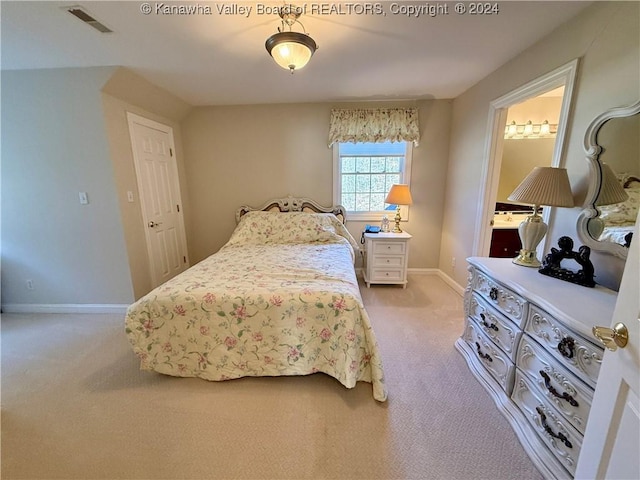 carpeted bedroom featuring ensuite bath