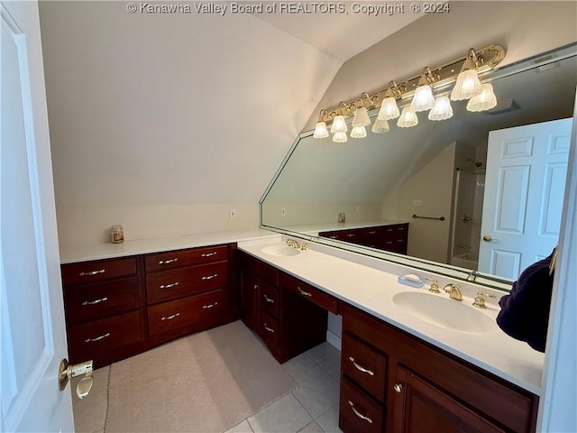 bathroom with tile patterned flooring, vanity, and lofted ceiling