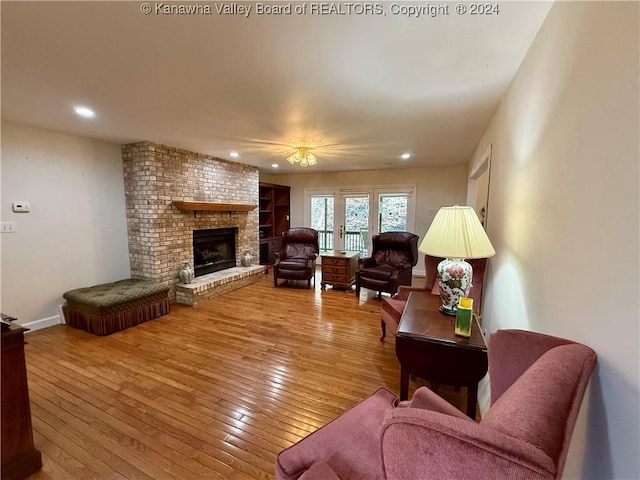 living room featuring light hardwood / wood-style floors and a brick fireplace