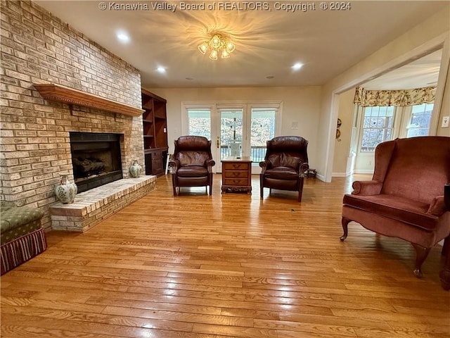 living room with light hardwood / wood-style floors and a brick fireplace