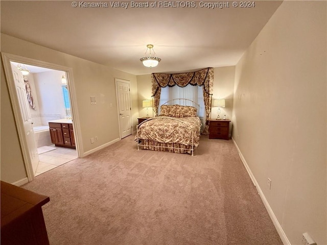 bedroom featuring ensuite bathroom, light carpet, and a closet