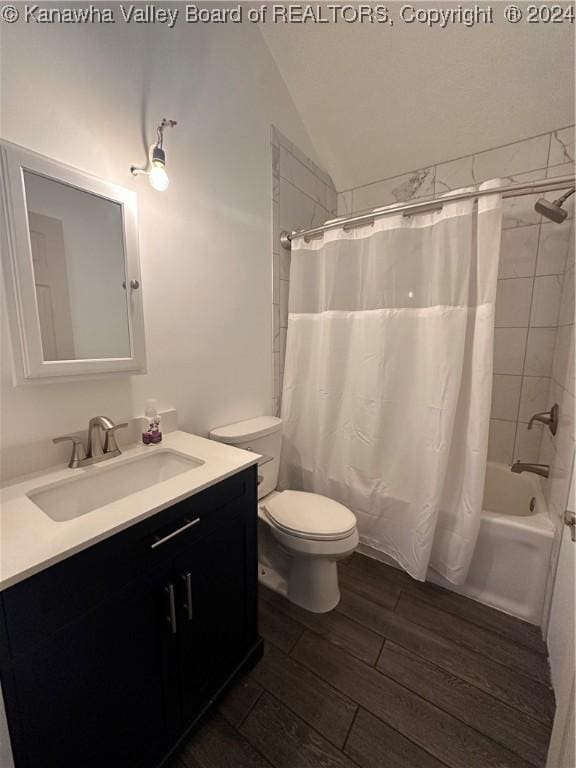 full bathroom with shower / tub combo, vanity, vaulted ceiling, hardwood / wood-style floors, and toilet