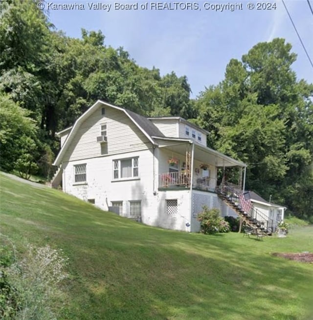 view of home's exterior featuring covered porch and a lawn