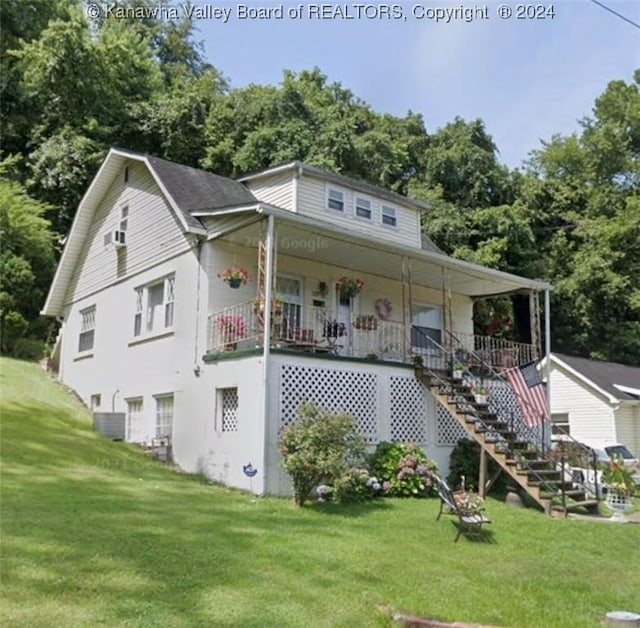 view of front of home with covered porch, central AC unit, and a front lawn