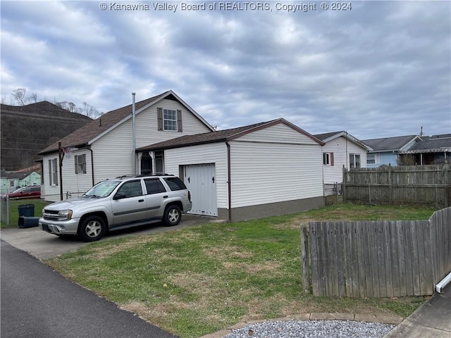 view of side of home with a lawn and a garage