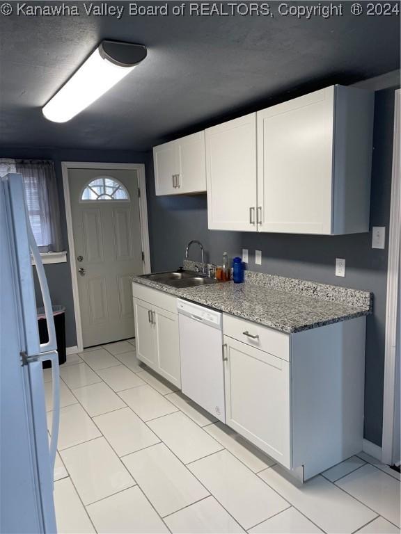 kitchen with white cabinetry, light tile patterned flooring, white appliances, and sink