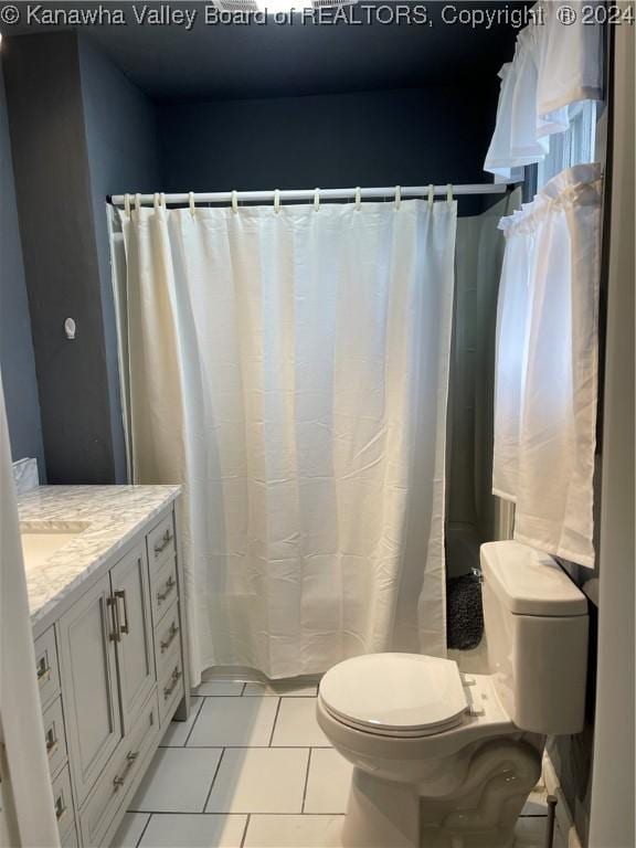 bathroom featuring tile patterned flooring, vanity, and toilet