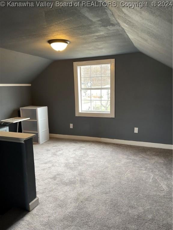 bonus room featuring carpet, a textured ceiling, and vaulted ceiling