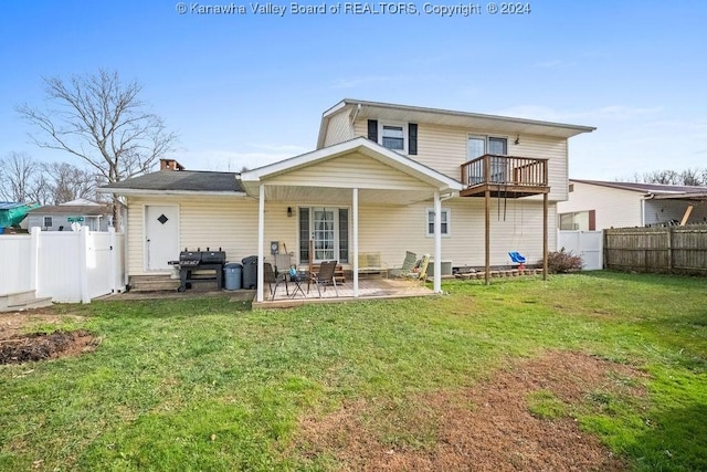 rear view of house featuring a lawn, a patio area, and a balcony