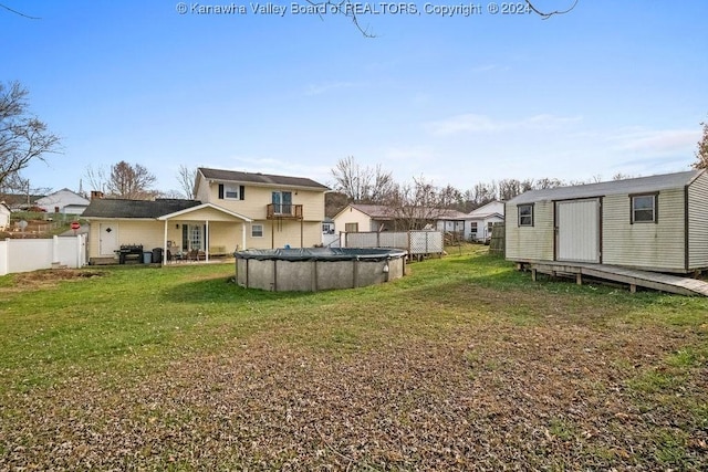 view of yard with a covered pool and a storage shed