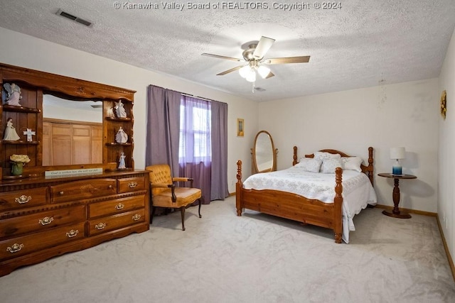 bedroom with light carpet, a textured ceiling, and ceiling fan