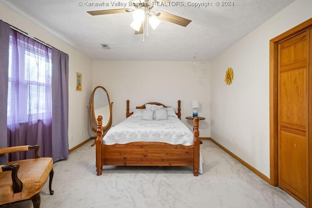 carpeted bedroom with a textured ceiling and ceiling fan