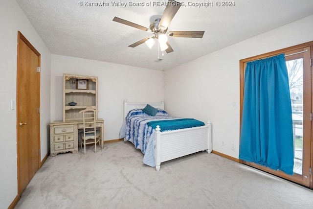 carpeted bedroom featuring multiple windows, ceiling fan, and a textured ceiling