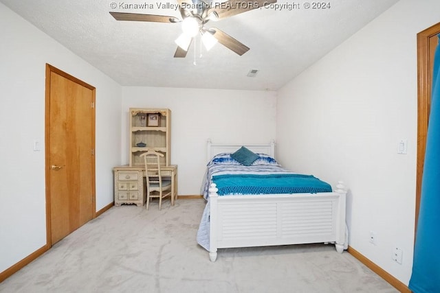 bedroom with carpet flooring, ceiling fan, and a textured ceiling