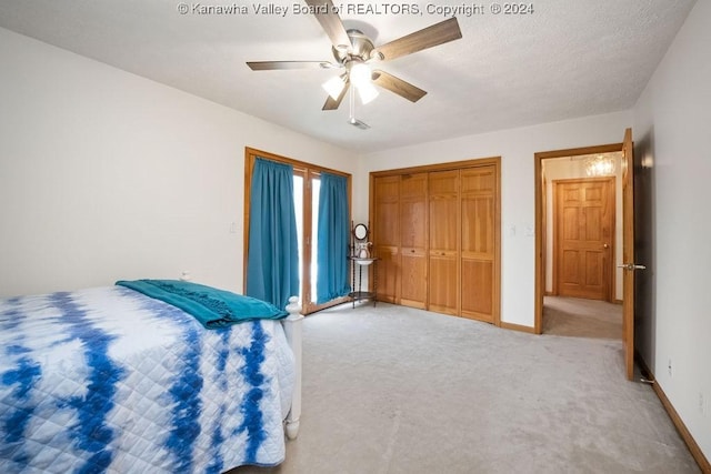 bedroom featuring light carpet, a textured ceiling, and ceiling fan