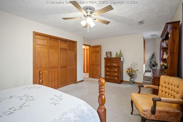 bedroom with light carpet, a textured ceiling, a closet, and ceiling fan