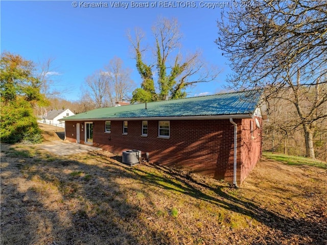 rear view of house featuring central AC unit